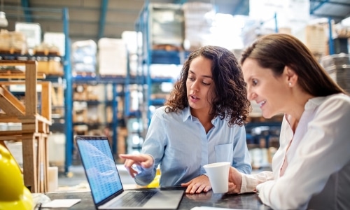 Dwie kobiety przy komputerze na magazynie